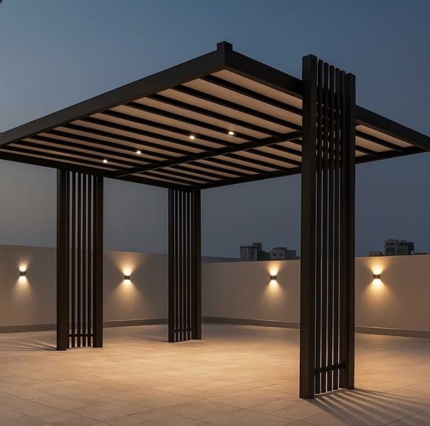Modern dark aluminum pergola shed with integrated ceiling lights and slatted post accents on a rooftop terrace at dusk
